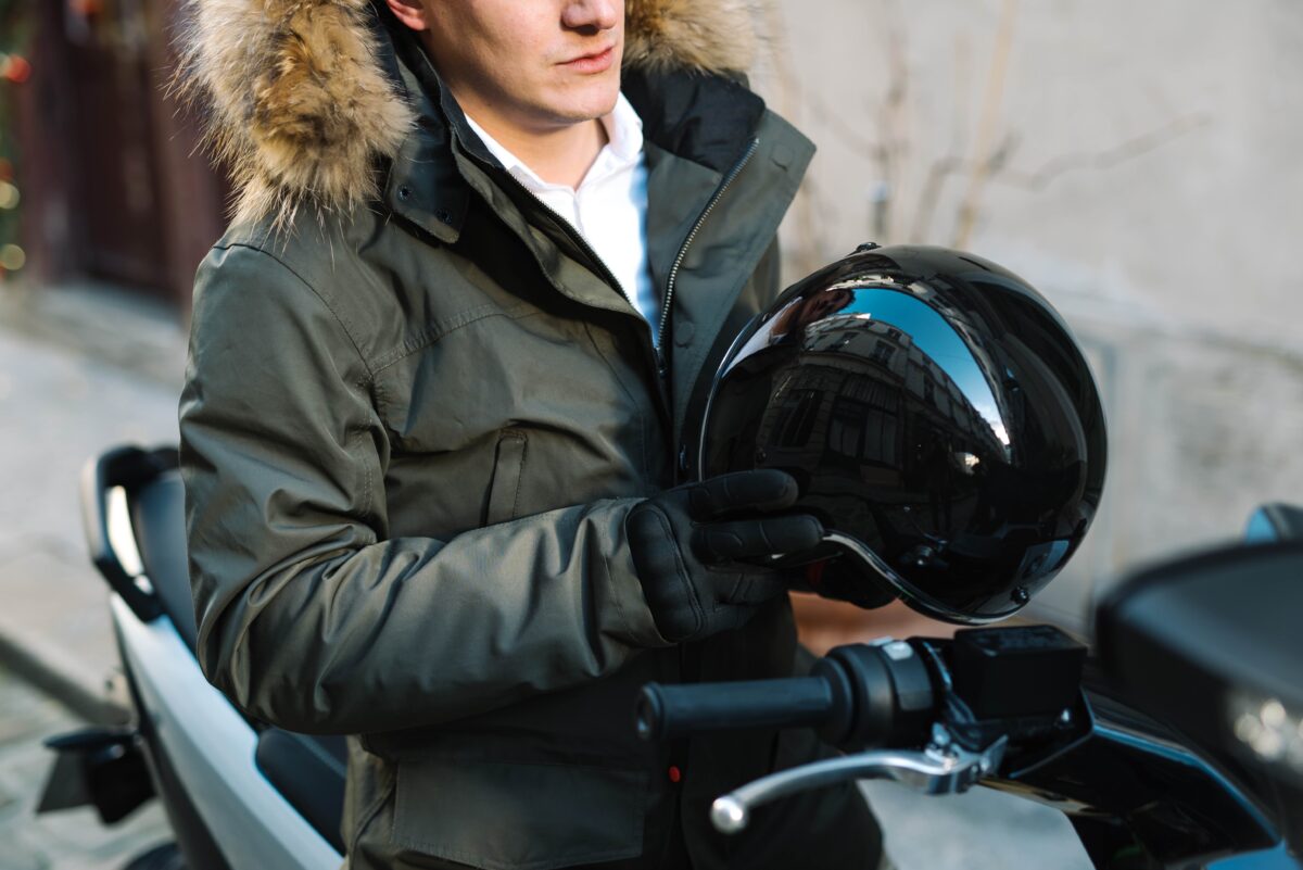 un homme avec un casque de moto à la main